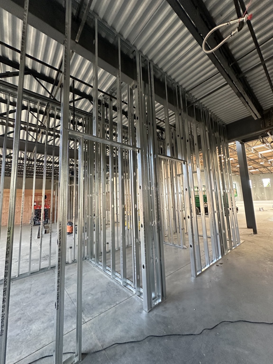 Commercial metal stud wall framing with framed door openings beneath an exposed steel deck